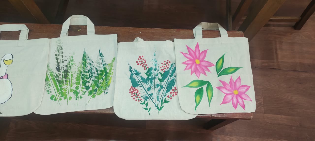 Tote bags painted with leaf prints and flowers, part of the finished collection