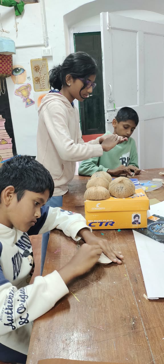 A student sanding a coconut shell smooth at the art table