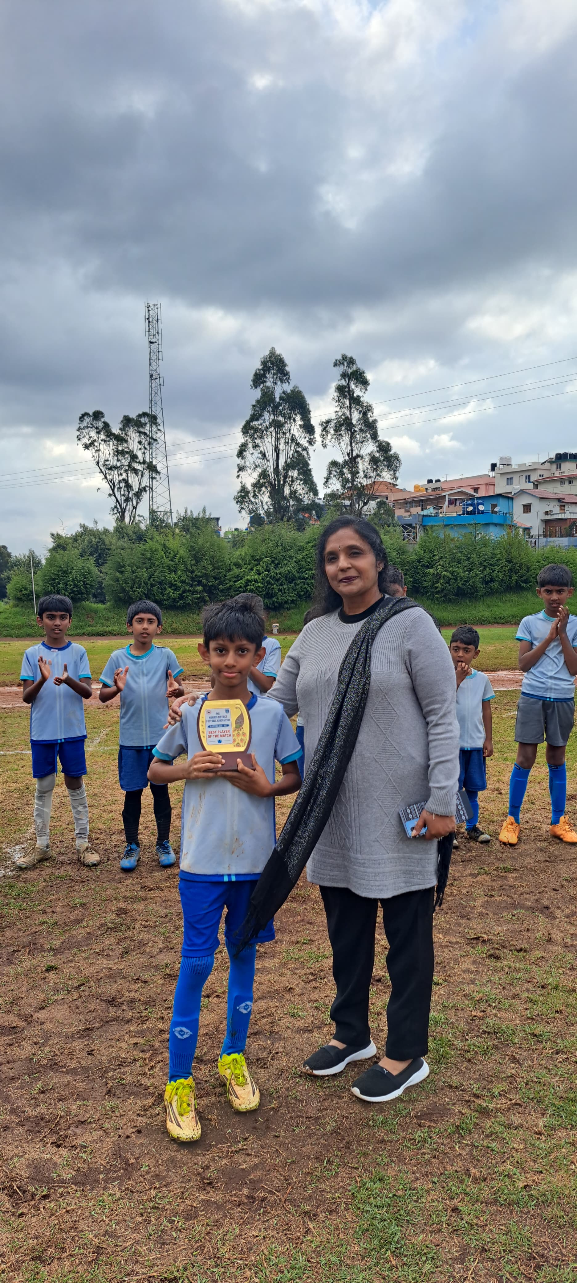 Vijay Mithran receiving the Best Player of the Match award from a tournament official, with teammates applauding