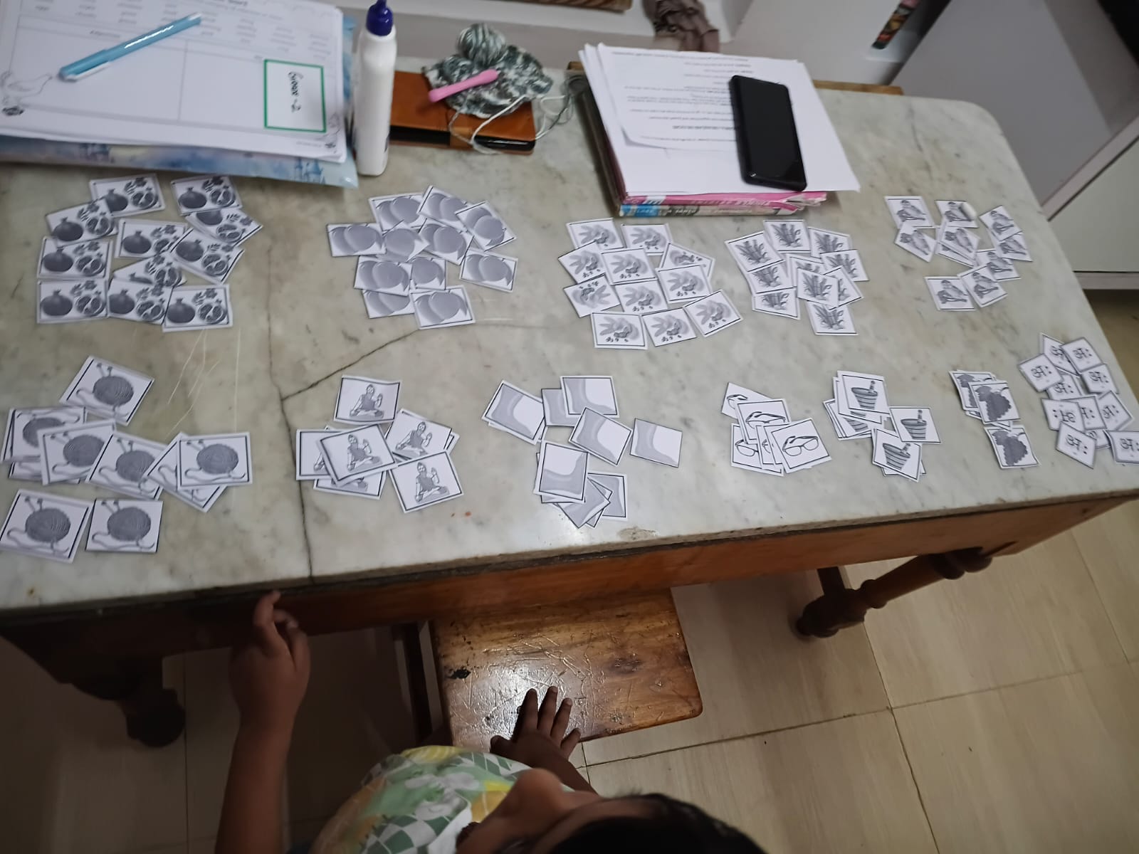 Hindi vowel picture flashcards sorted into piles on a table