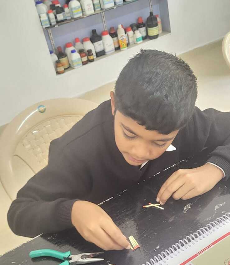 A student cutting matchsticks to length with pliers