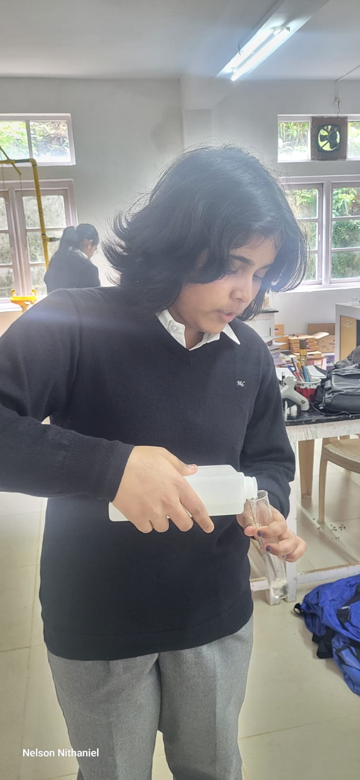 A student pouring ethanol into a test tube