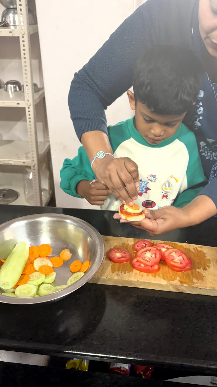 teacher helping a first step child slice cucumber at bms