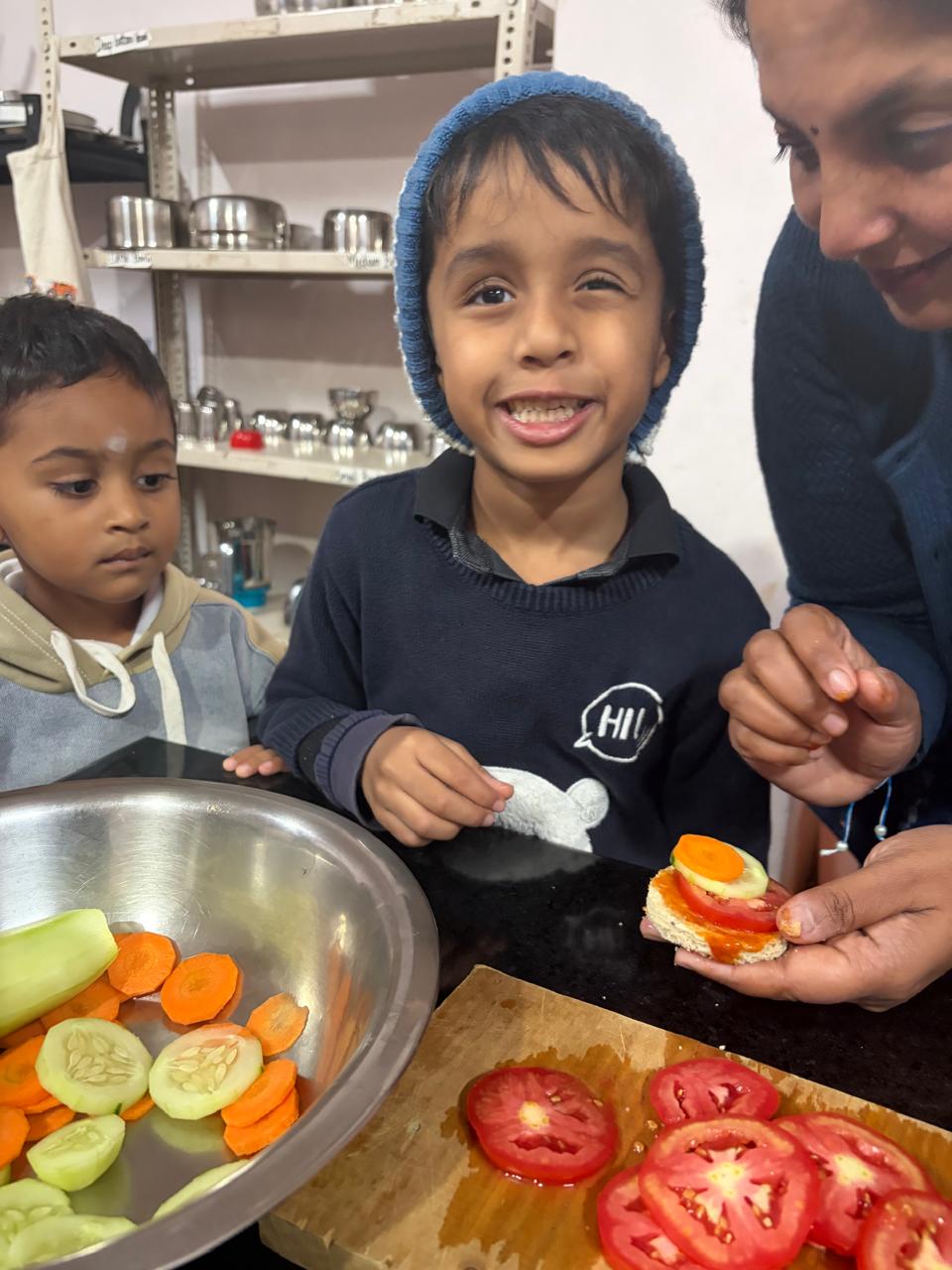 smiling first step child holding a finished veggie sandwich at bms