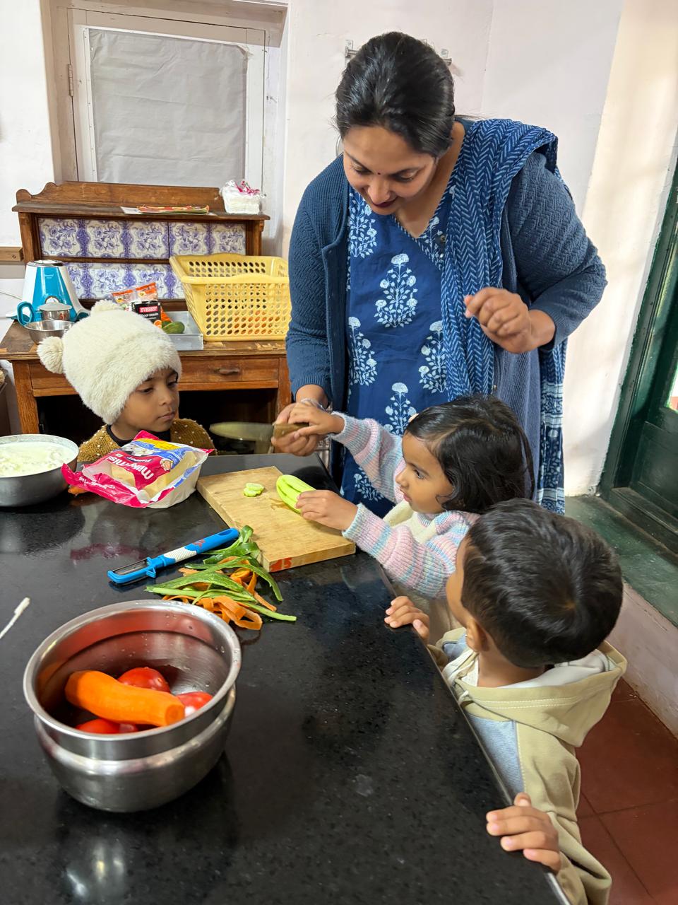 teacher and first step children preparing vegetables at bms