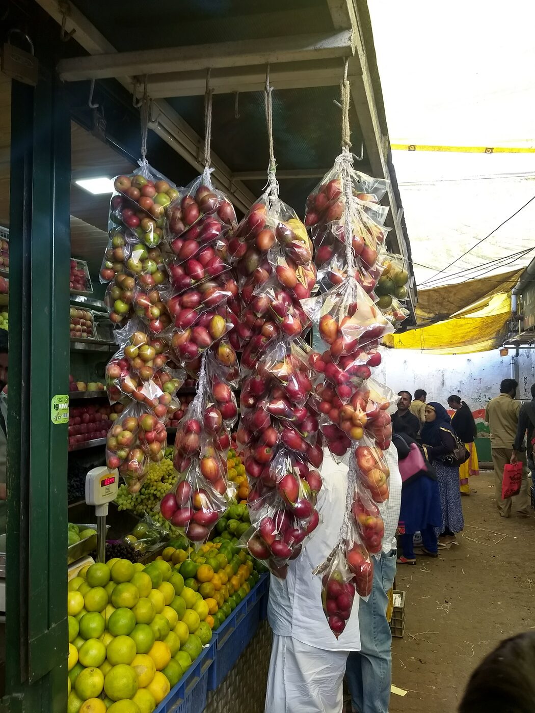 Bunches of fruit hanging at a produce stall